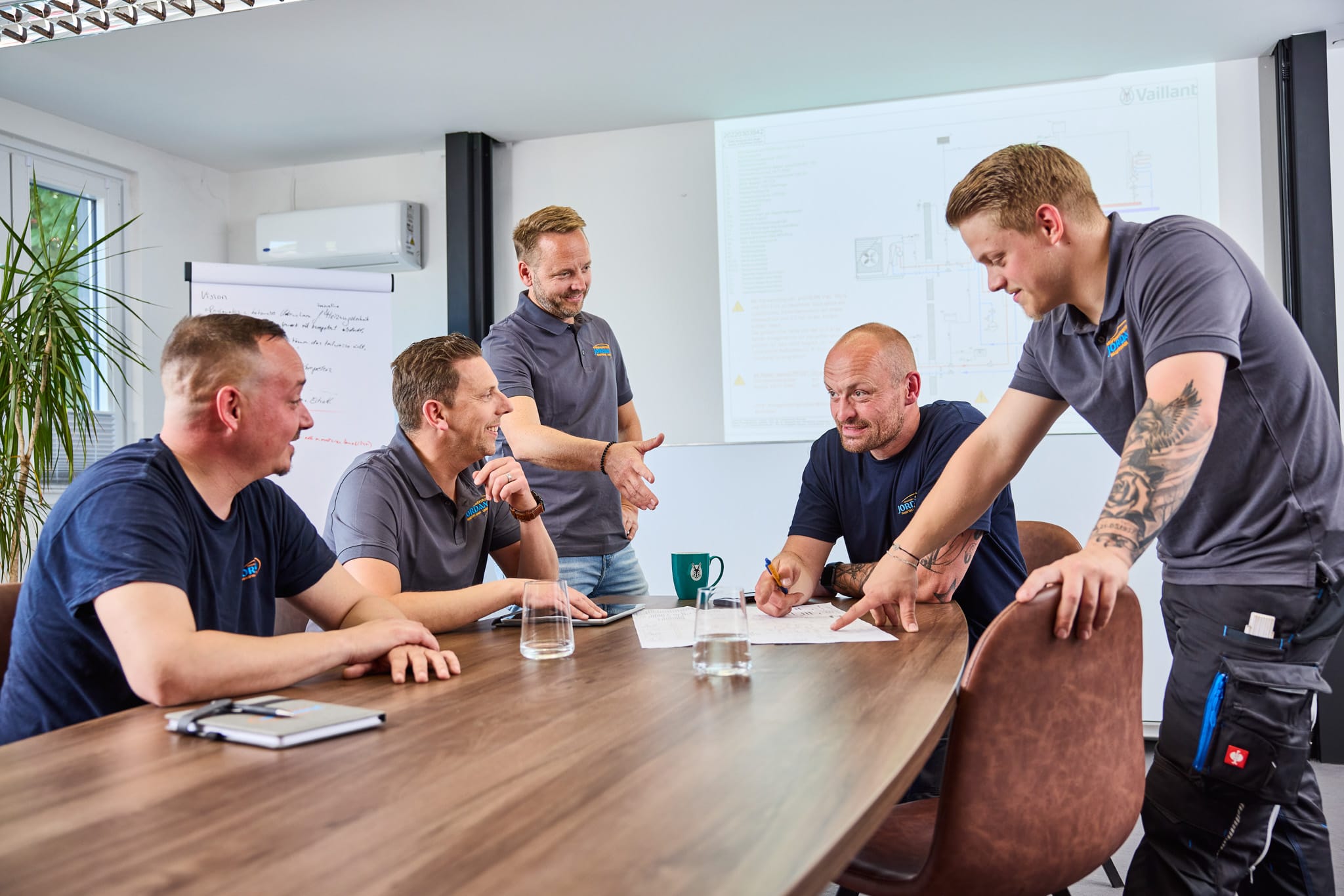Team der Jordan Haustechnik GmbH bei einer Besprechung zu technischen Plänen im Konferenzraum